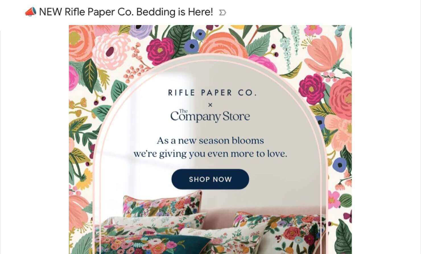 company-store-new-product-line-announcement-email - OptinMonster eCommerce marketing email from The Company Store. Subject line says "NEW Rifle Paper Co. Bedding is Here!" Email says, "RIFLE PAPER CO x The Company Store. As a new season blooms we're giving you even more to love." CTA button says "Shop Now." Photo of bedding with floral designs.